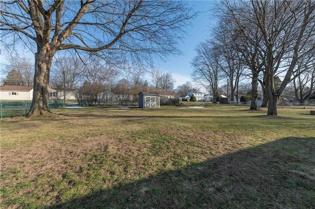 view of yard with an outdoor structure, fence, and a shed