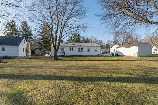 back of property featuring an outdoor structure and a yard