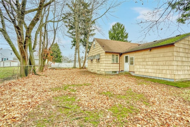 rear view of property featuring entry steps and fence