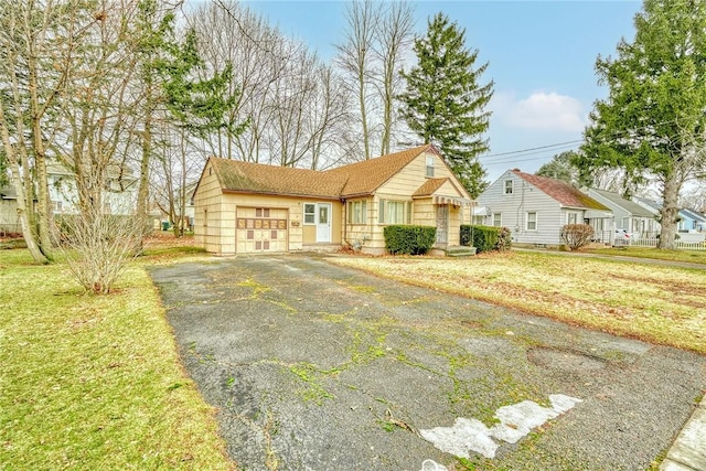 view of front facade featuring a front lawn, a garage, and driveway