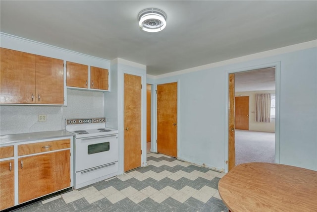 kitchen featuring light countertops, light floors, brown cabinets, and white range with electric stovetop