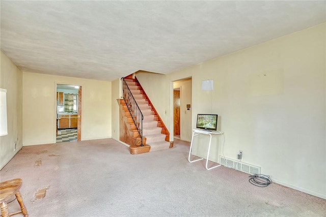 interior space with visible vents, baseboards, carpet, and stairs