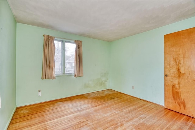 spare room with wood finished floors and baseboards