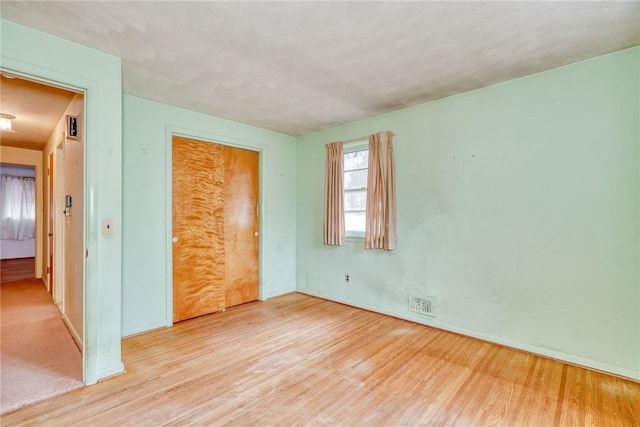 empty room featuring visible vents and wood finished floors