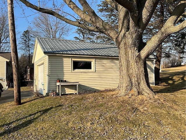 view of property exterior with metal roof and a garage