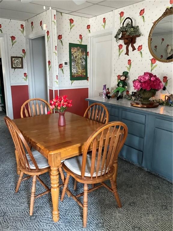 dining area with a drop ceiling, wainscoting, wallpapered walls, and carpet floors