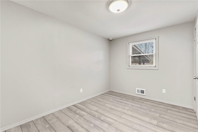 unfurnished room featuring visible vents, light wood-type flooring, and baseboards