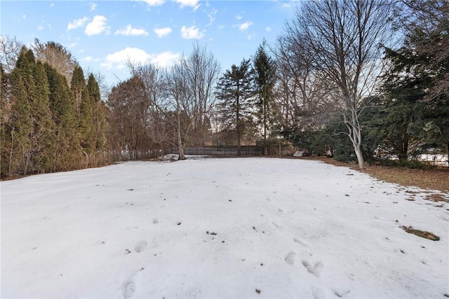 yard covered in snow featuring fence