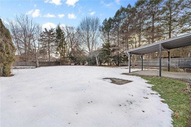 yard covered in snow featuring fence