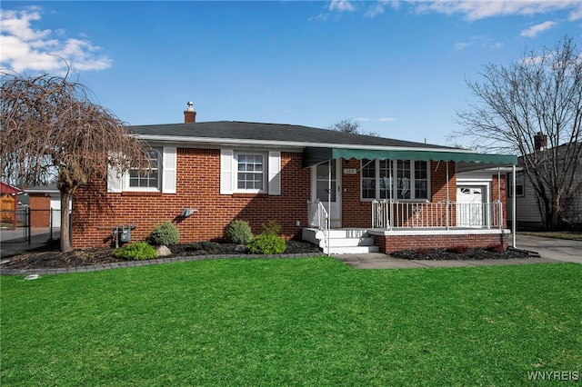 view of front of property with a chimney, brick siding, covered porch, and a front yard