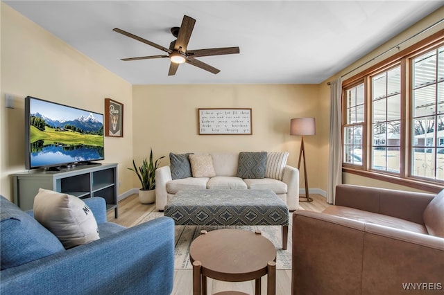 living room featuring wood finished floors, baseboards, and ceiling fan