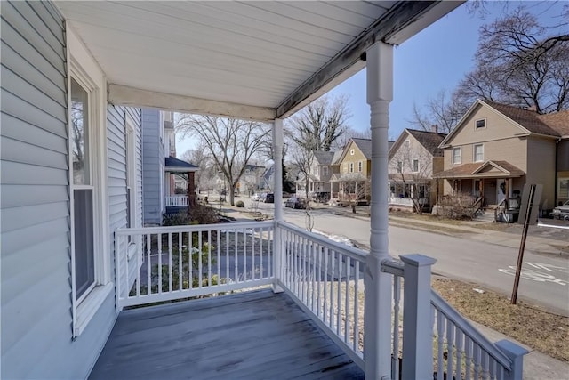 wooden terrace featuring a residential view and covered porch