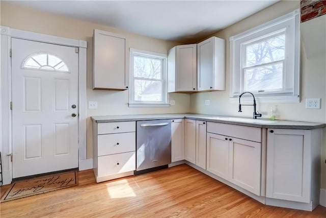 kitchen featuring a sink, white cabinetry, light wood-type flooring, and stainless steel dishwasher