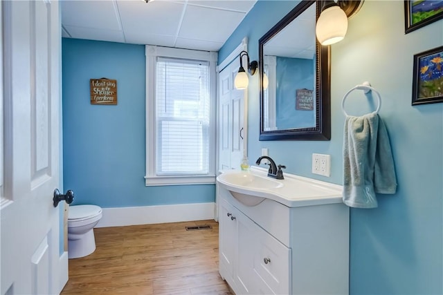 bathroom with vanity, wood finished floors, toilet, and a healthy amount of sunlight