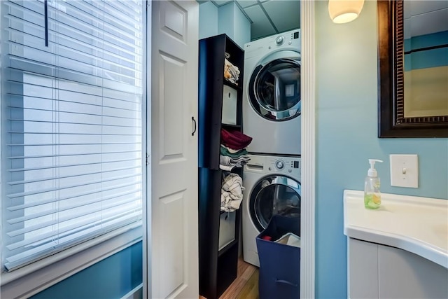 laundry room featuring stacked washer / drying machine and laundry area