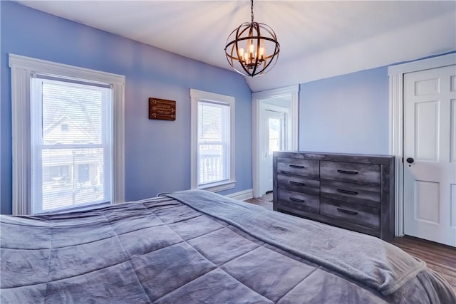 bedroom featuring a notable chandelier and wood finished floors