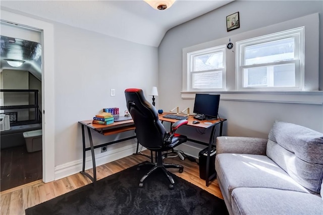 home office with baseboards, wood finished floors, and vaulted ceiling