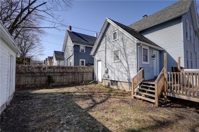 back of property with a deck and fence