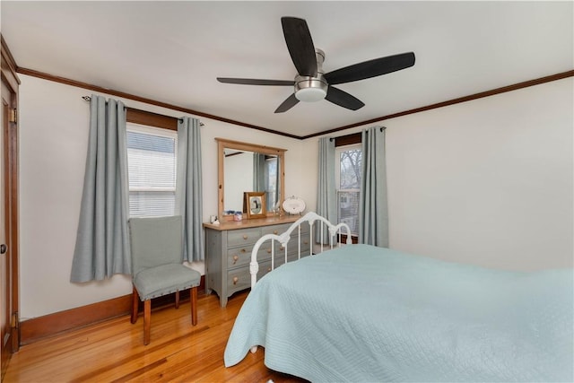 bedroom with multiple windows, light wood-style floors, and ornamental molding