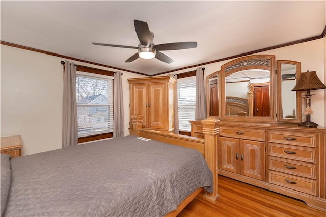 bedroom with crown molding, multiple windows, light wood finished floors, and ceiling fan