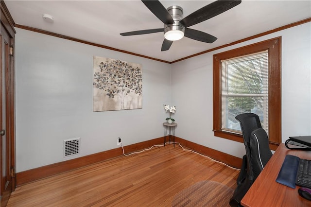 office area with visible vents, baseboards, light wood-style floors, and crown molding