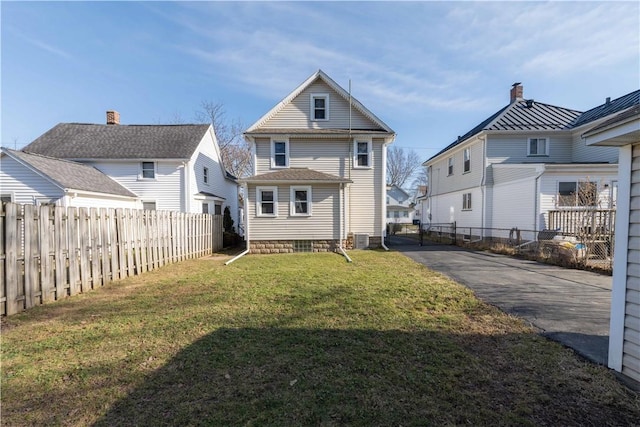 back of house featuring a yard, cooling unit, driveway, and fence