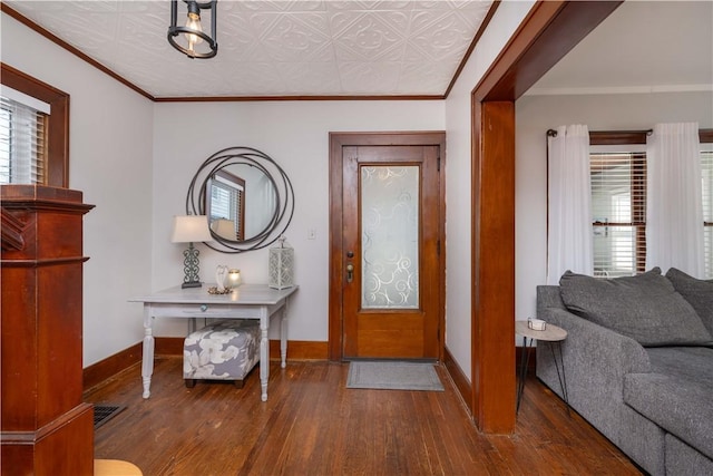 entrance foyer featuring an ornate ceiling, crown molding, baseboards, and hardwood / wood-style floors