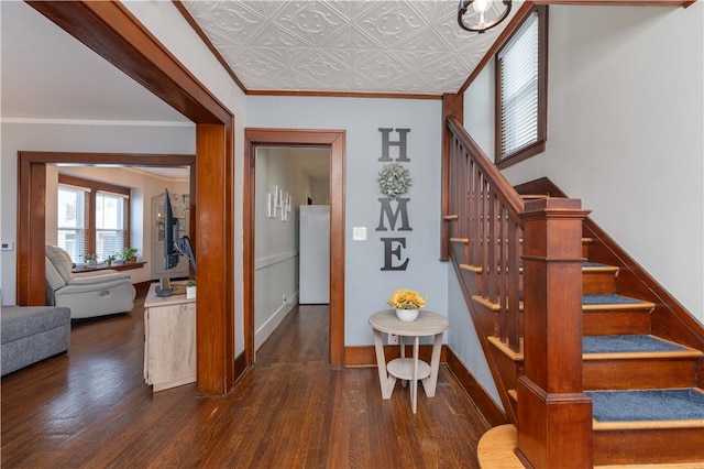 stairway with ornamental molding, an ornate ceiling, baseboards, and wood finished floors