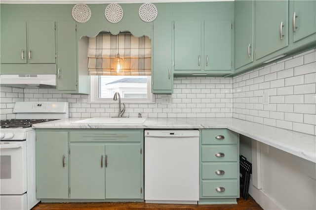 kitchen featuring under cabinet range hood, decorative backsplash, white appliances, and a sink