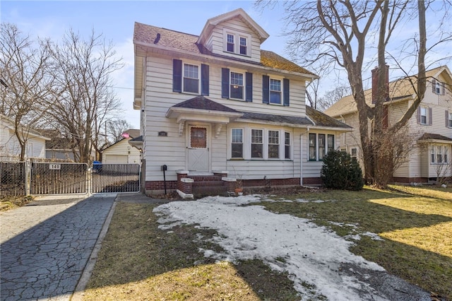 american foursquare style home featuring entry steps, roof with shingles, a front yard, and fence