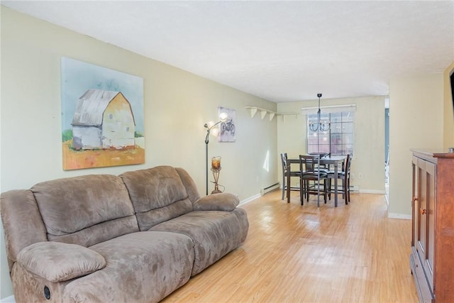 living room with an inviting chandelier, light wood-style floors, baseboards, and a baseboard radiator