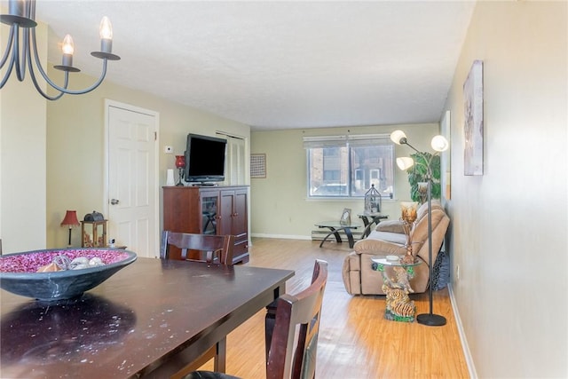 living area featuring baseboard heating, baseboards, and wood finished floors