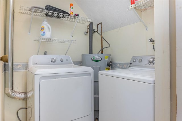 laundry area featuring washer and clothes dryer, laundry area, a textured ceiling, and water heater