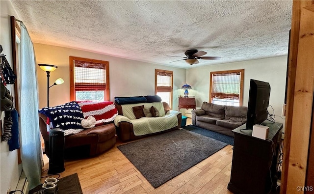 living room with light wood finished floors, a textured ceiling, and a ceiling fan