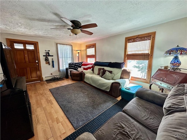 living area with light wood-type flooring, a textured ceiling, a ceiling fan, and a baseboard radiator