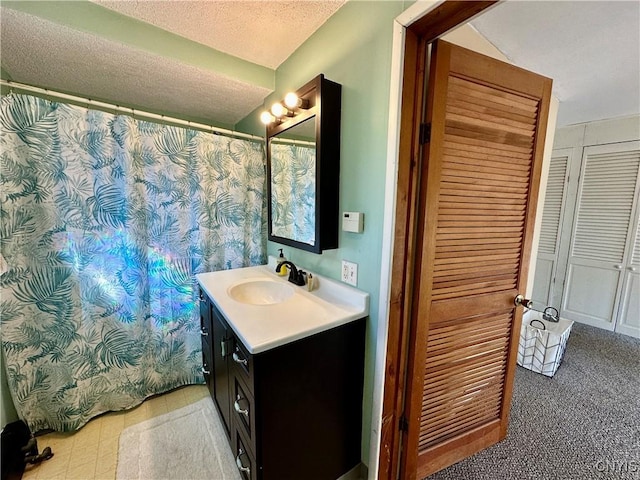 bathroom with tile patterned floors, a closet, a textured ceiling, and vanity