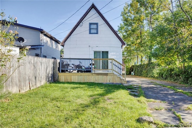 rear view of property with a yard and aphalt driveway