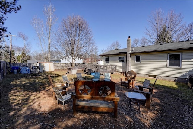 view of yard with an outbuilding, a shed, an outdoor fire pit, and a fenced backyard