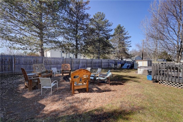 view of yard with a deck, a fire pit, and a fenced backyard