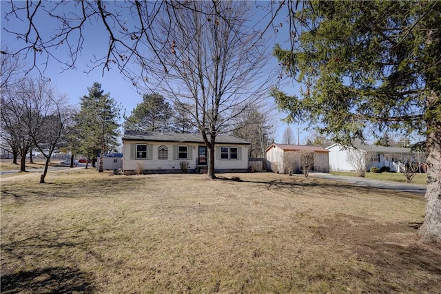 ranch-style house with driveway and a front lawn