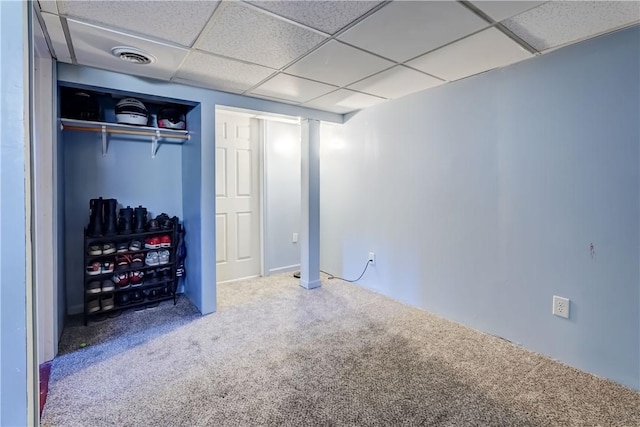 finished basement featuring carpet, visible vents, and a paneled ceiling