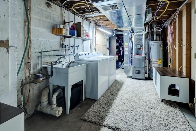 basement featuring gas water heater, separate washer and dryer, and visible vents