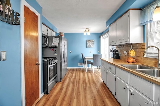 kitchen featuring tasteful backsplash, a healthy amount of sunlight, stainless steel appliances, and a sink