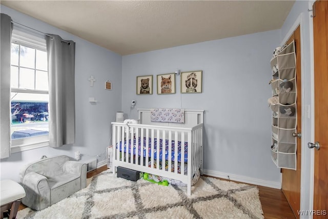 bedroom with visible vents, baseboards, and wood finished floors