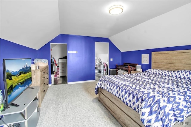 bedroom with a spacious closet, baseboards, lofted ceiling, carpet floors, and a closet