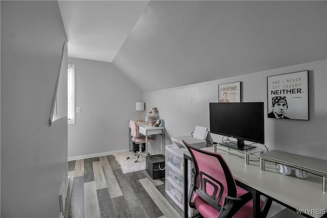 office space featuring baseboards, lofted ceiling, and wood finished floors