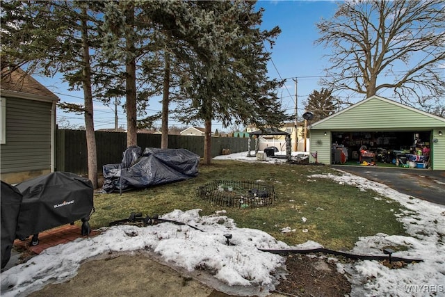 view of yard featuring a detached garage, an outdoor structure, and fence