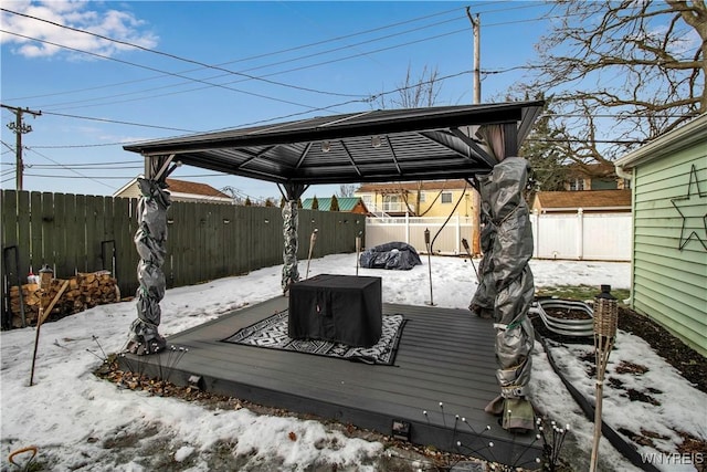 snow covered deck featuring a gazebo and a fenced backyard