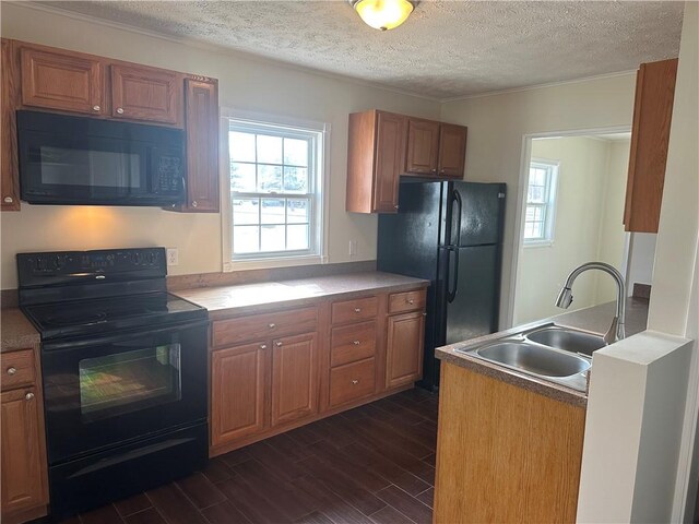 kitchen with black appliances, brown cabinets, dark wood-style floors, a textured ceiling, and a sink