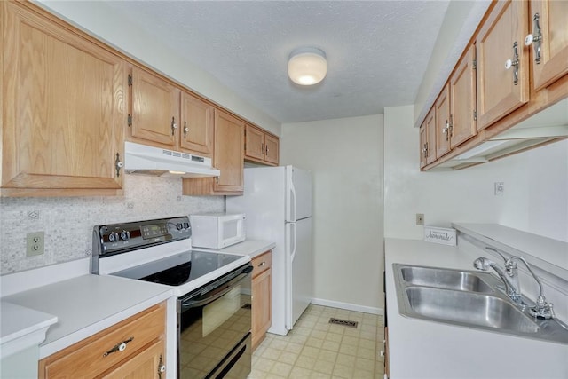 kitchen featuring white appliances, light countertops, under cabinet range hood, and a sink